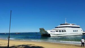 Car carrying ferry pulling up on the beach